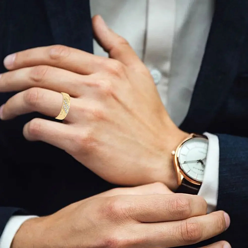 Man wearing a gold diamond ring and gold wristwatch, dressed in a suit
