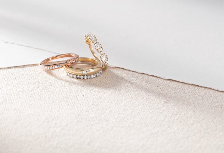 Rose and yellow gold diamond promise rings on ivory linen – Picasso Gold & Diamond Chicago