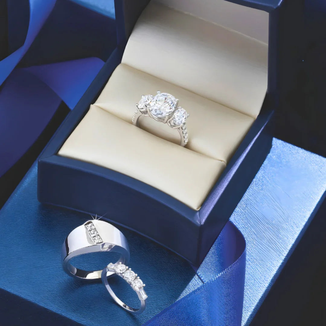 Trio of diamond rings in a blue jewelry box, featuring a sparkling engagement ring set.