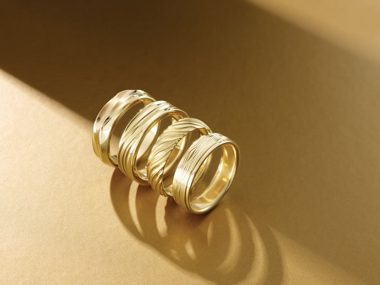 Textured 14K yellow gold wedding bands in warm light – Picasso Gold & Diamond Chicago