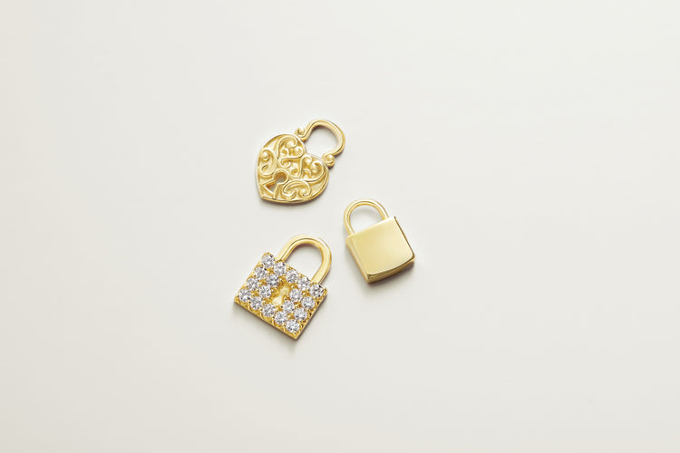 Gold and pavé diamond padlock charms on ivory – Picasso Gold & Diamond Chicago