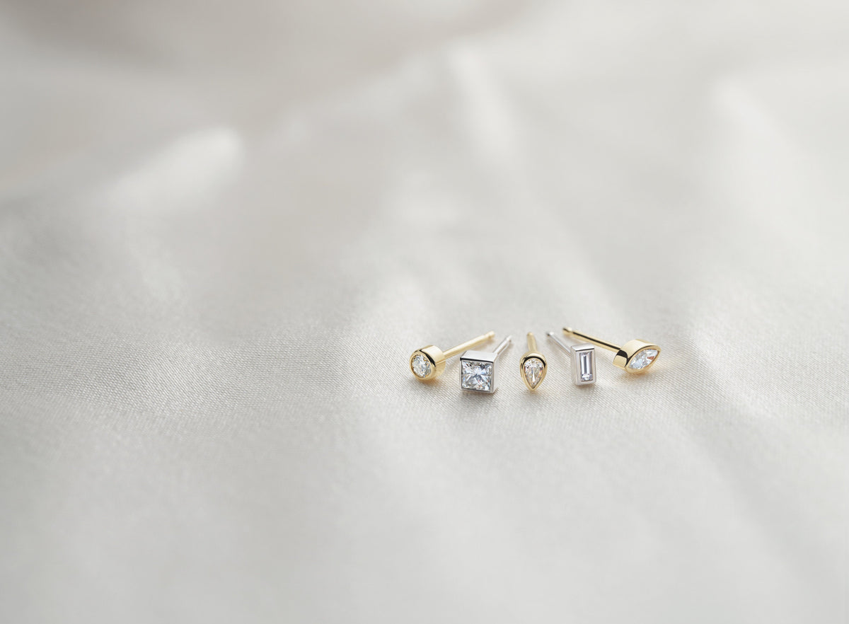 Diamond bezel stud earrings on ivory satin – Picasso Gold & Diamond Chicago