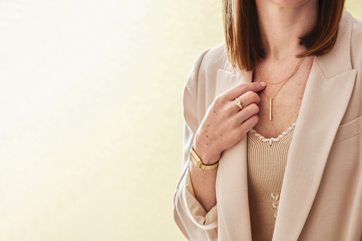 Gold bar necklace worn at the collarbone with camel blazer – Picasso Gold & Diamond Chicago