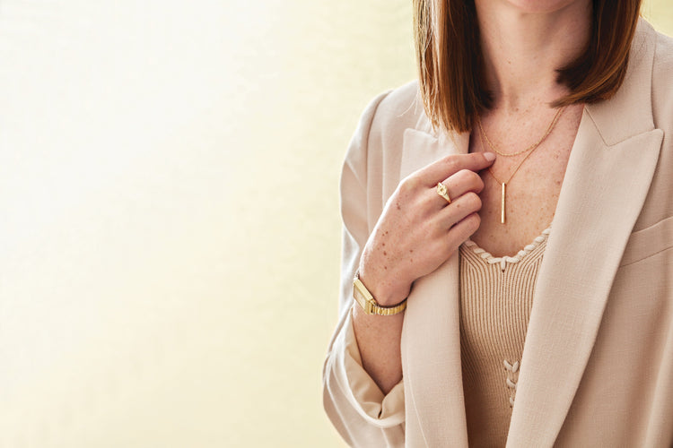 Gold bar necklace worn at the collarbone with camel blazer – Picasso Gold & Diamond Chicago