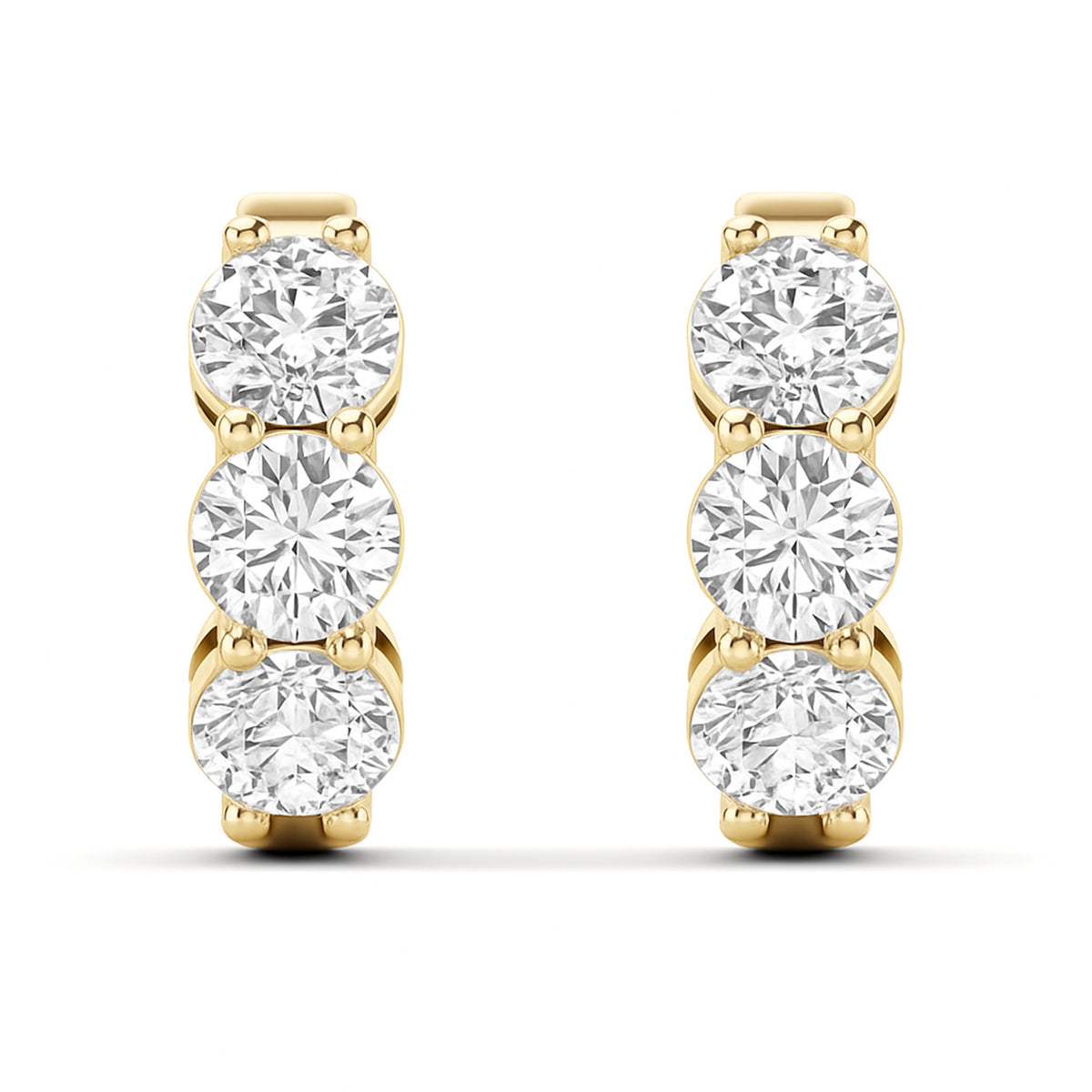 A pair of yellow gold hoop earrings featuring three round-cut clear lab grown diamonds in a vertical setting on each earring, shown against a plain white background. 1.9 CT Diamond Huggie Hoops Earrings } Picasso Gold & Diamond Jewelry