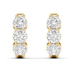 A pair of yellow gold hoop earrings featuring three round-cut clear lab grown diamonds in a vertical setting on each earring, shown against a plain white background. 1.9 CT Diamond Huggie Hoops Earrings } Picasso Gold & Diamond Jewelry