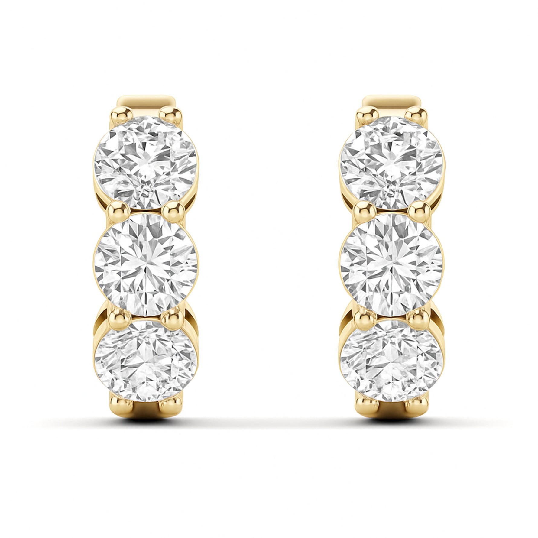 A pair of yellow gold hoop earrings featuring three round-cut clear lab grown diamonds in a vertical setting on each earring, shown against a plain white background. 1.9 CT Diamond Huggie Hoops Earrings } Picasso Gold & Diamond Jewelry