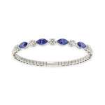 Elegant 14k White Gold diamond bangle, featuring 6.5 CTW lab diamond / lab blue sapphire, in a round / marquise cut, close-up detail shot.